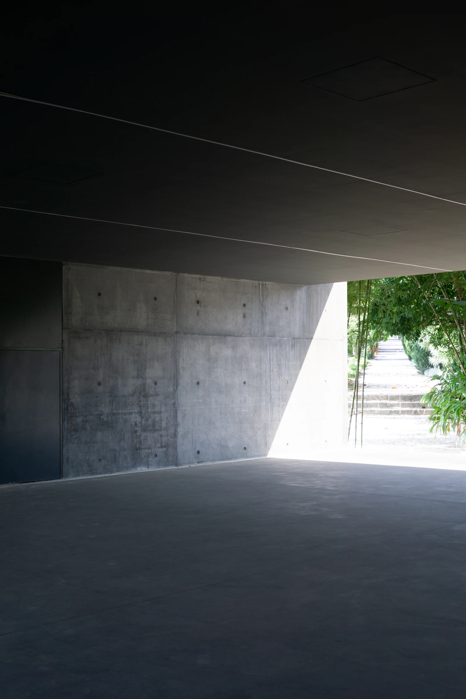 Concrete underpass opening onto green trees
